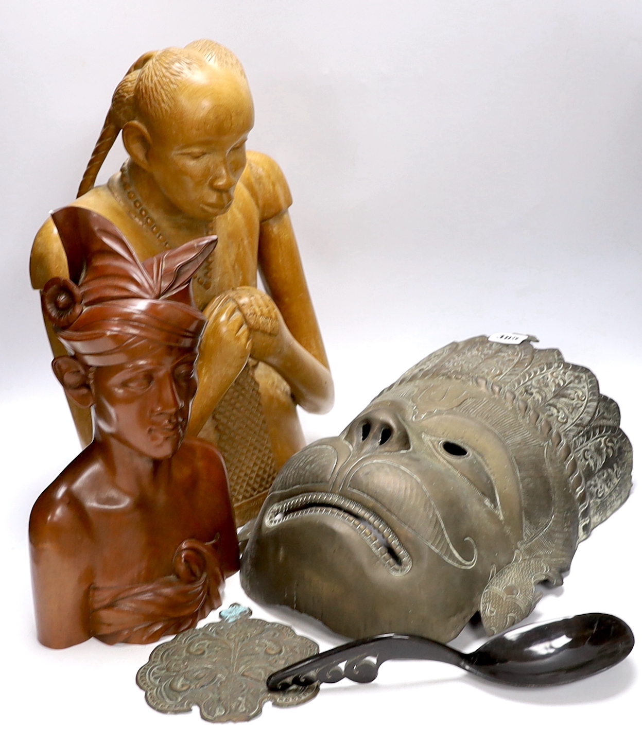 A West African carving of a girl, and a Balinese bust of a man together with an Indonesian metal mask and black lacquered spoon, mask 38cm high